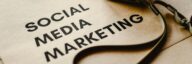Close-up of a camera placed on brown paper with 'Social Media Marketing' text, emphasizing digital marketing themes.